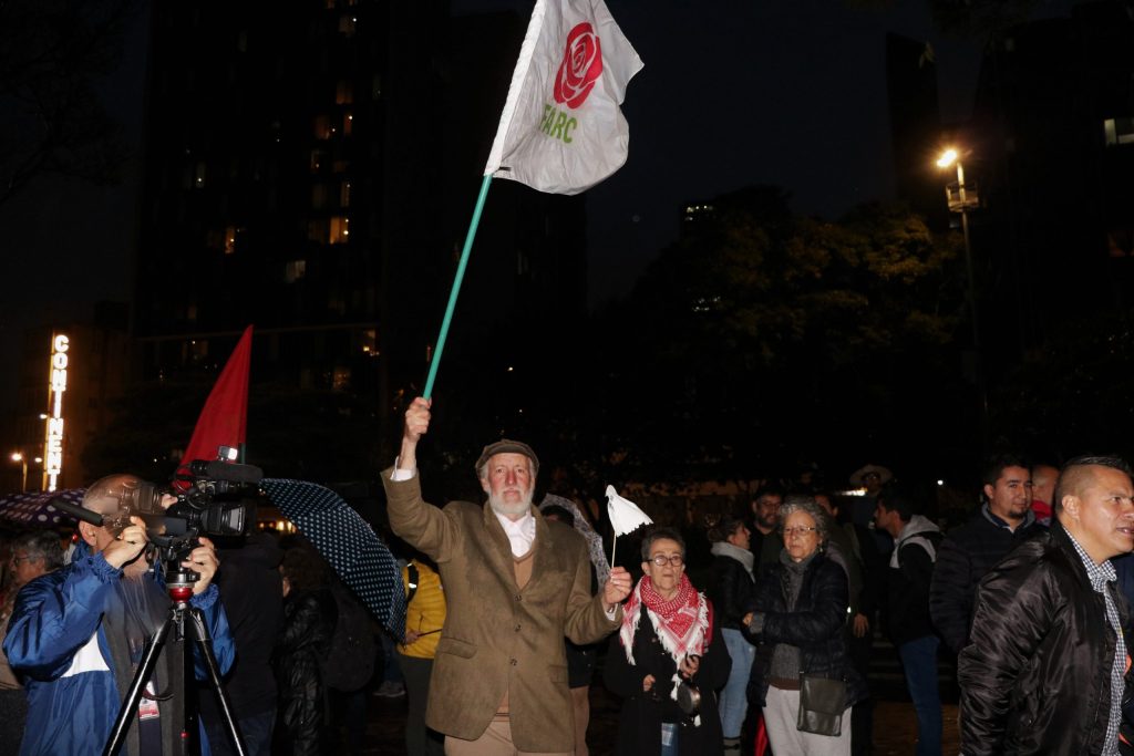 hombre bandera scaled 228 asesinatos de personas que dejaron las armas no han impedido que la paz siga caminando